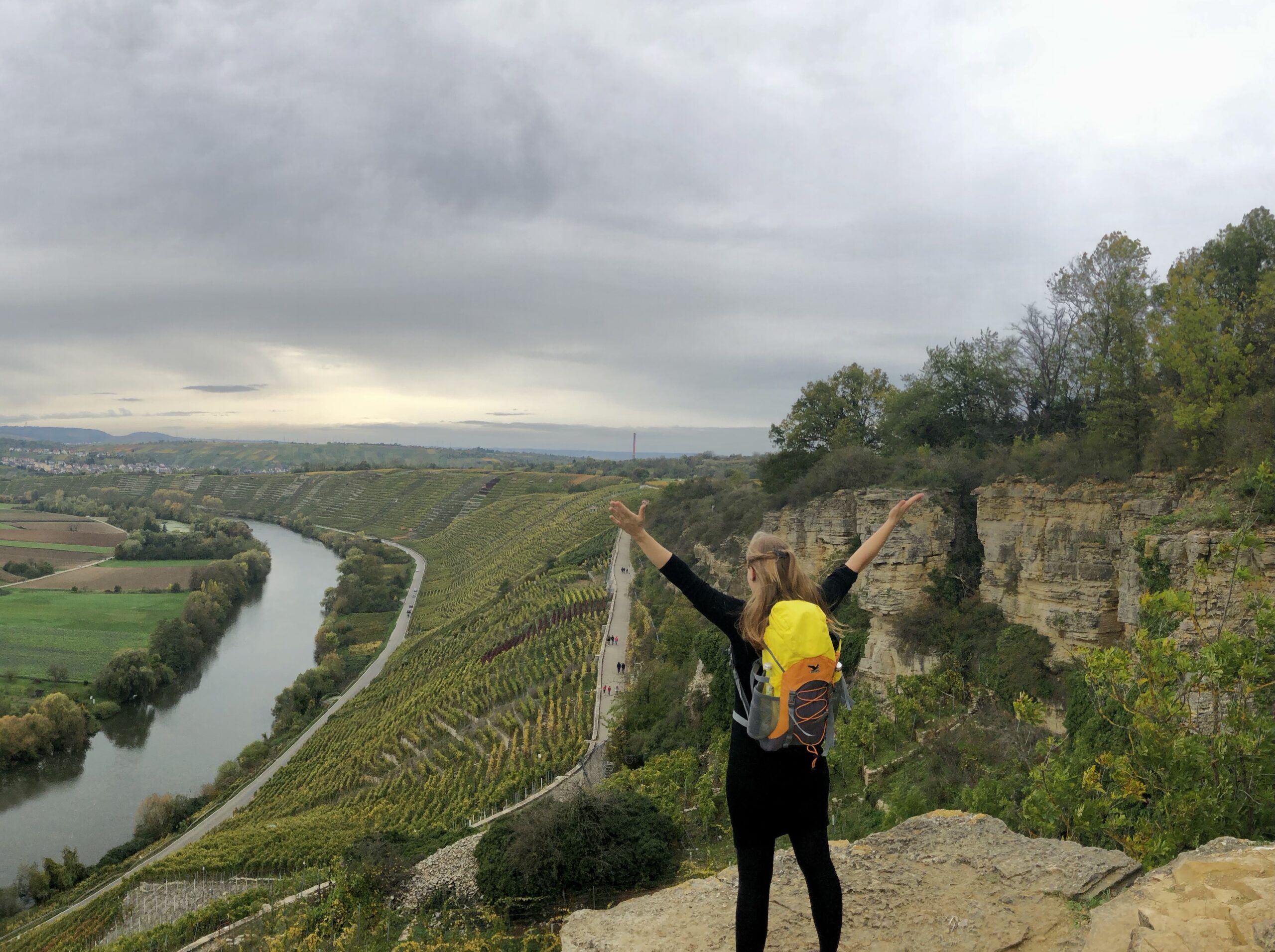 Mareike Walther standing confidently on a rock ledge overlooking vineyards, symbolizing empowerment and freedom in nature