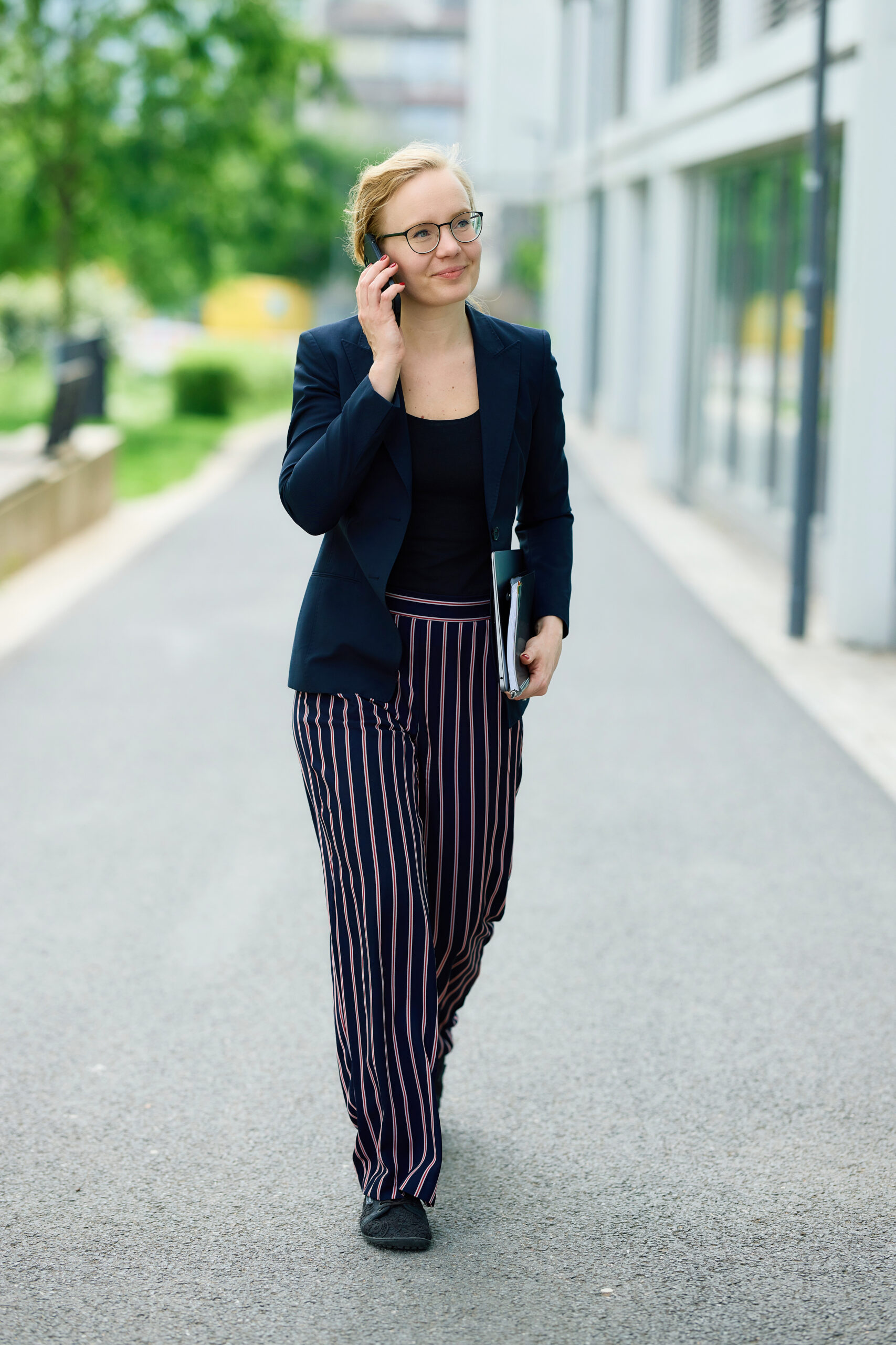 Mareike Walther full-body portrait talking on the phone with a warm, approachable smile in natural light
